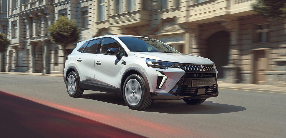 Der Mitsubishi Grandis Ein weißer Mitsubishi Grandis fährt durch die Stadt.