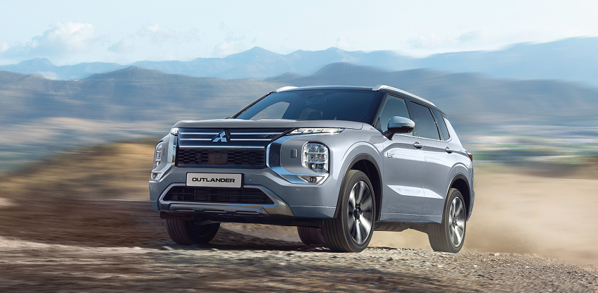 Der Mitsubishi Outlander Ein grauer Mitsubishi Outlander fährt durchs Gelände.