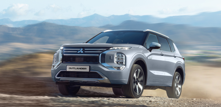 Der Mitsubishi Outlander Ein grauer Mitsubishi Outlander fährt durchs Gelände.