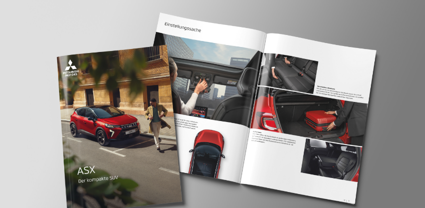 Die Mitsubishi ASX Broschüre Die aufgeblätterte Broschüre des ASX liegt auf grauem Untergrund.