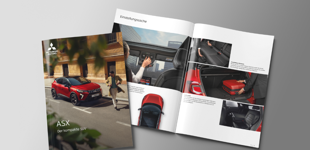 Die Mitsubishi ASX Broschüre Die aufgeblätterte Broschüre des ASX liegt auf grauem Untergrund.