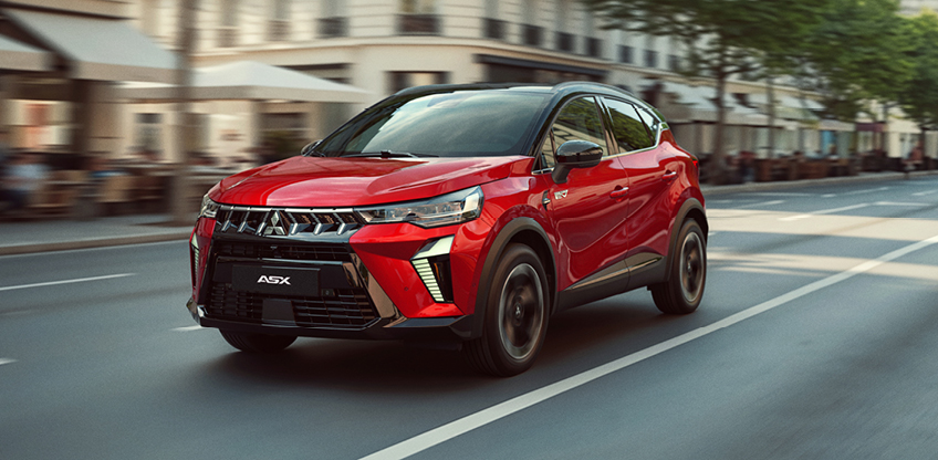 Mitsubishi ASX Rot Seitenansicht bei Fahrt durch die Stadt Roter Mitsubishi ASX Select in der Seitenansicht bei Fahrt durch eine Stadtstraße mit verschwommenem Hintergrund und Gebäuden