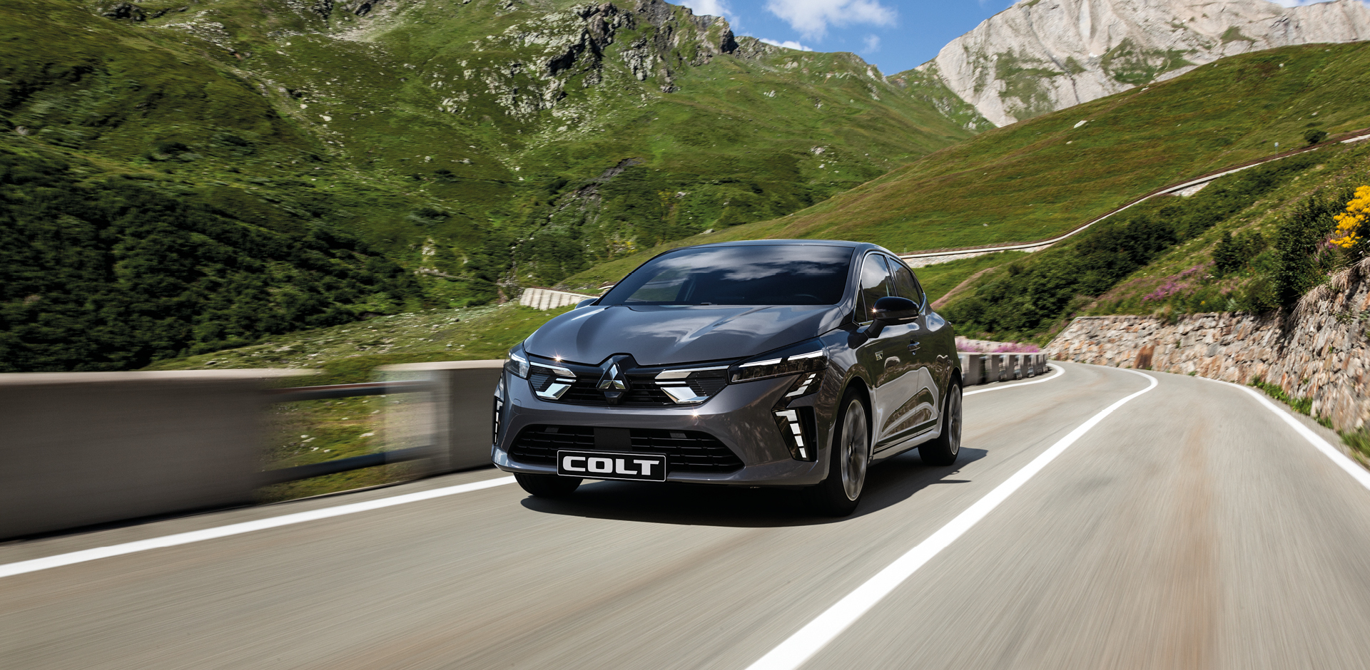 Der Mitsubishi COLT Ein grauer Mitsubishi COLT fährt eine Bergstraße entlang