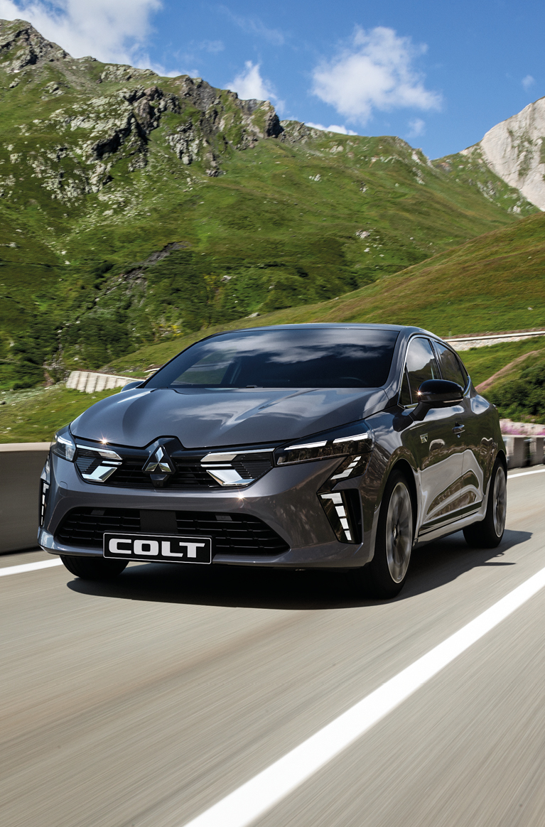 Der Mitsubishi COLT Ein grauer Mitsubishi COLT fährt eine Bergstraße entlang