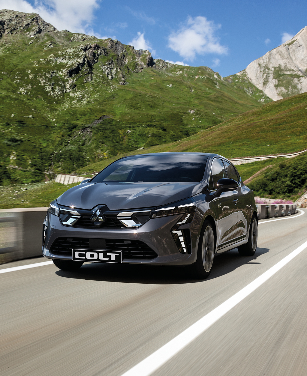 Der Mitsubishi COLT Ein grauer Mitsubishi COLT fährt eine Bergstraße entlang