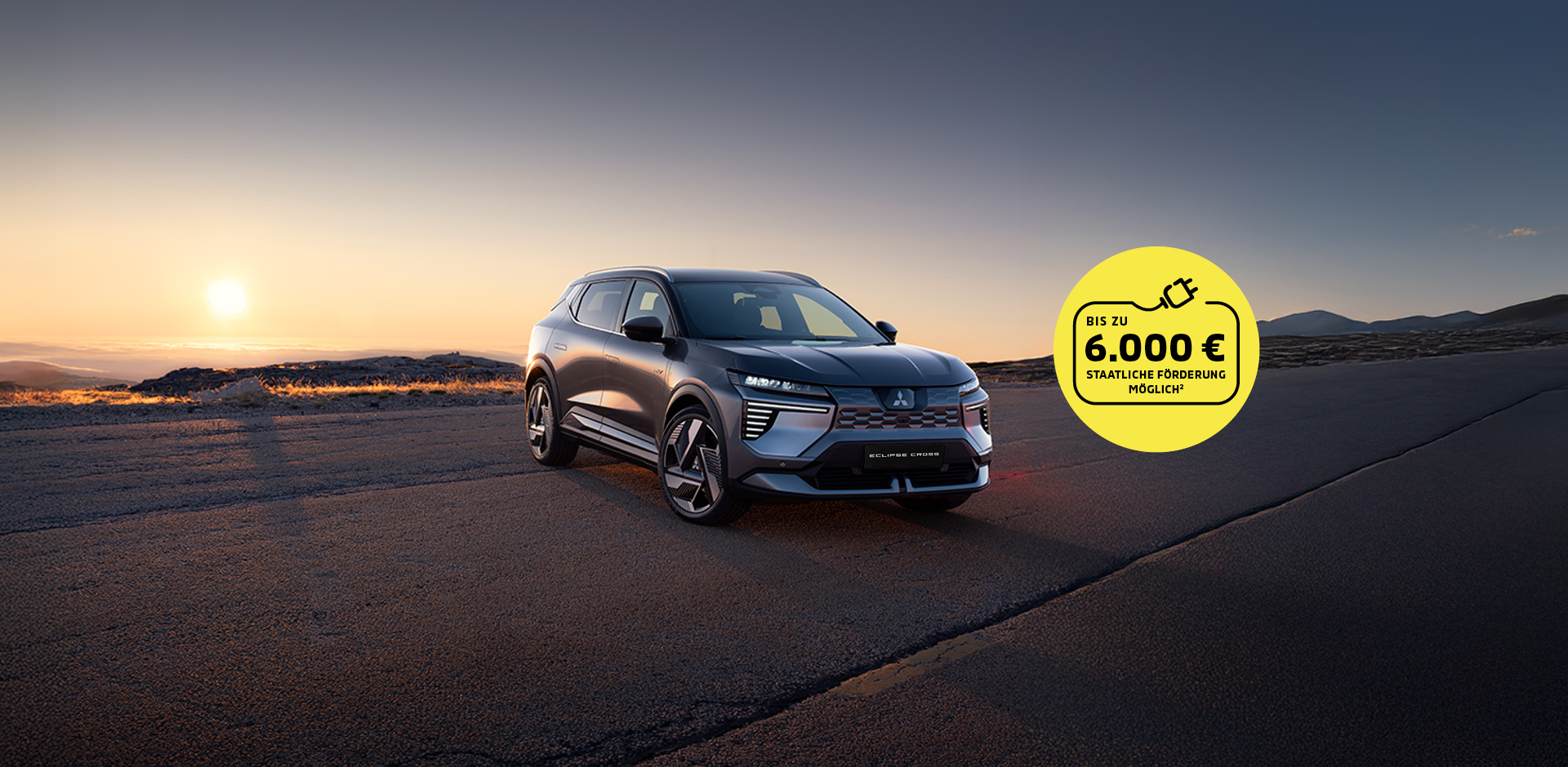 Mitsubishi Eclipse Cross mit Prämienhinweis Neuer Mitsubishi Eclipse Cross auf asphaltierter Straße im Sonnenuntergang. Gelber Kreis mit Hinweis auf staatliche Förderung bis zu 6.000 Euro.