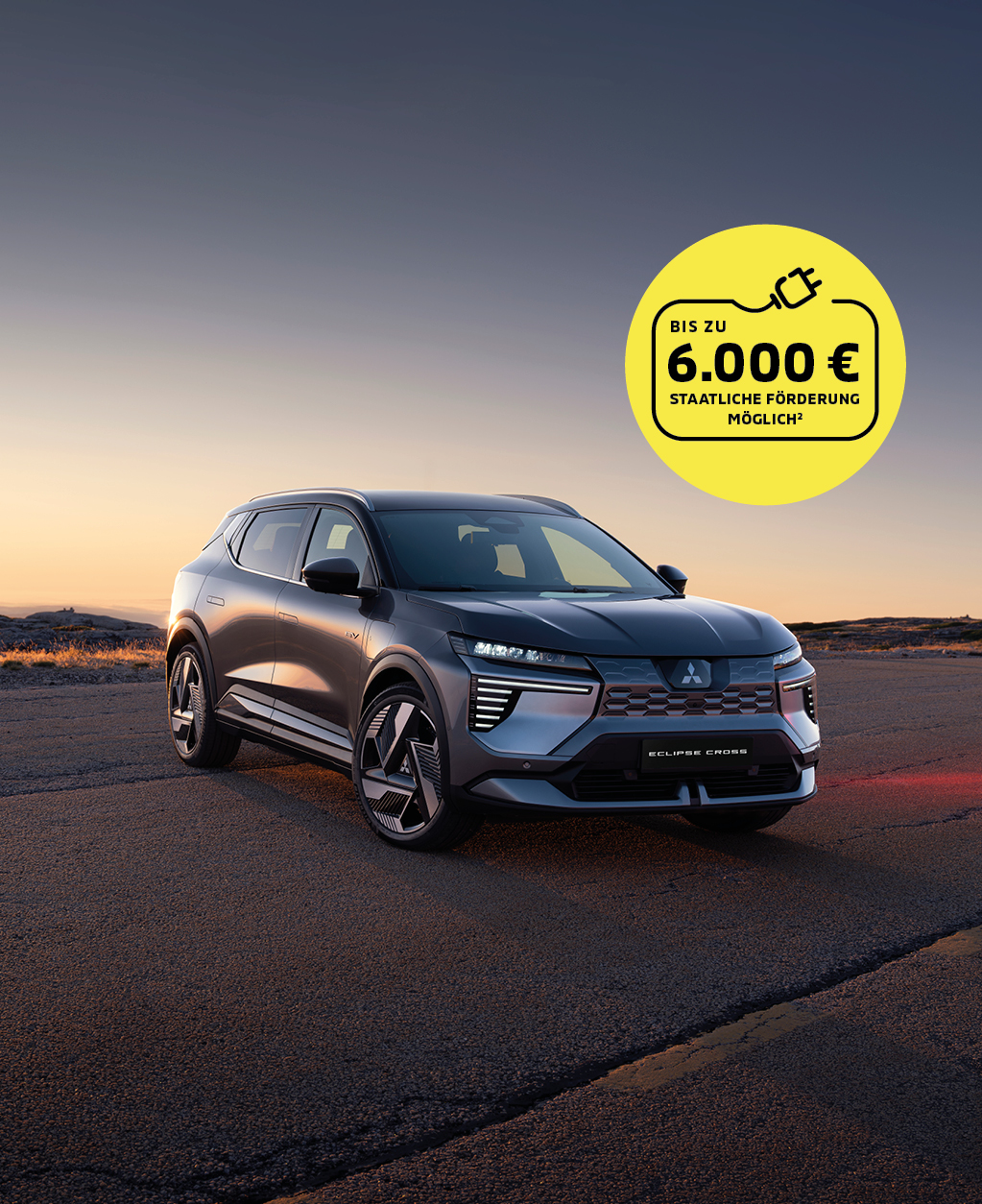 Mitsubishi Eclipse Cross mit Prämienhinweis Neuer Mitsubishi Eclipse Cross auf asphaltierter Straße im Sonnenuntergang. Gelber Kreis mit Hinweis auf staatliche Förderung bis zu 6.000 Euro.
