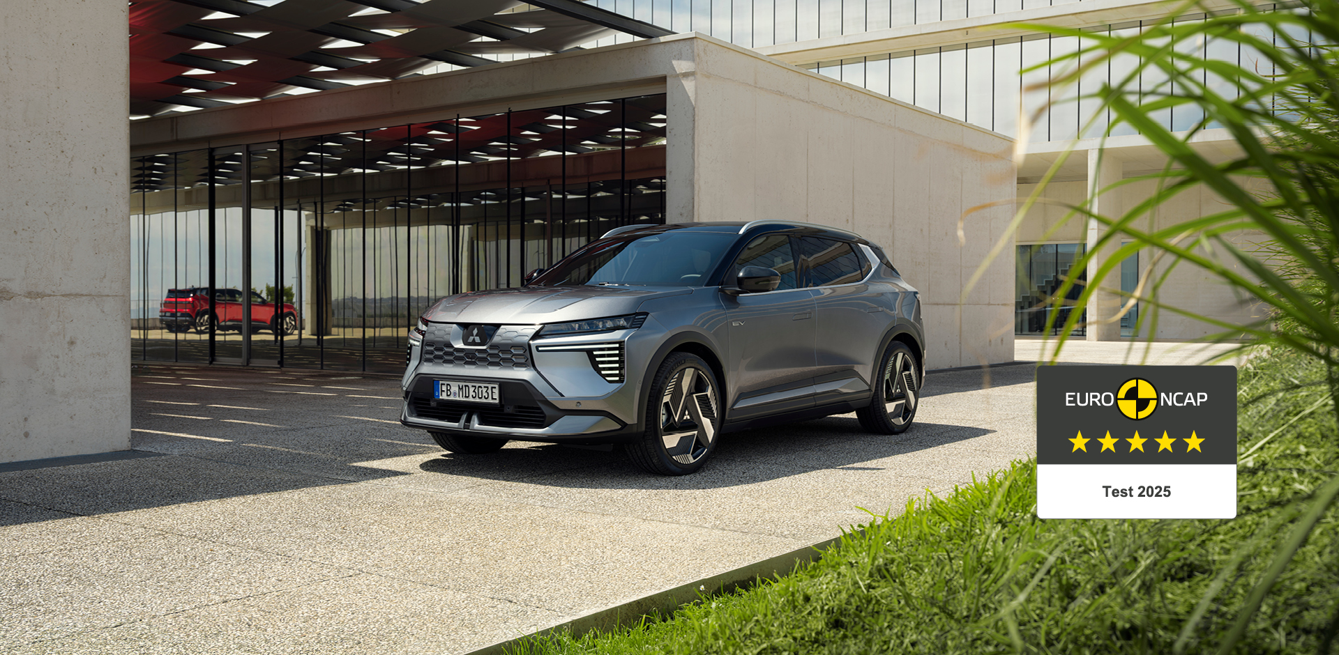 Der neue Eclipse Cross erhält 5 Sterne im Euro NCAP-Test. Der neue Mitsubishi Eclipse Cross steht vor einer Galerie, rechts daneben das 5-Sterne-Euro NCAP-Logo.