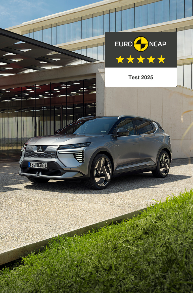 Der neue Eclipse Cross erhält 5 Sterne im Euro NCAP-Test. Der neue Mitsubishi Eclipse Cross steht vor einer Galerie, rechts daneben das 5-Sterne-Euro NCAP-Logo.