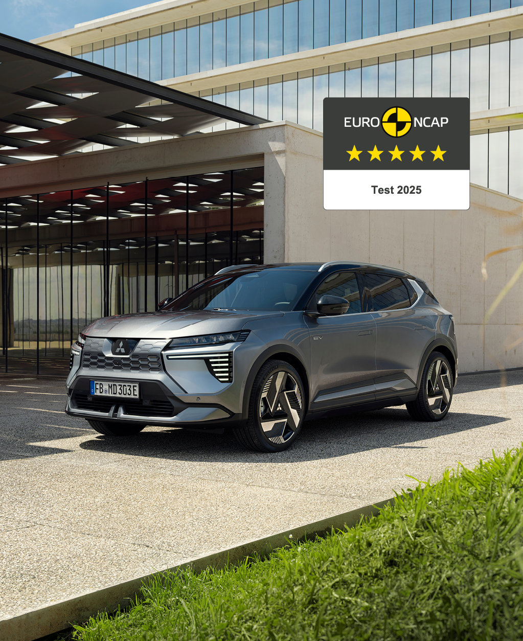 Der neue Eclipse Cross erhält 5 Sterne im Euro NCAP-Test. Der neue Mitsubishi Eclipse Cross steht vor einer Galerie, rechts daneben das 5-Sterne-Euro NCAP-Logo.