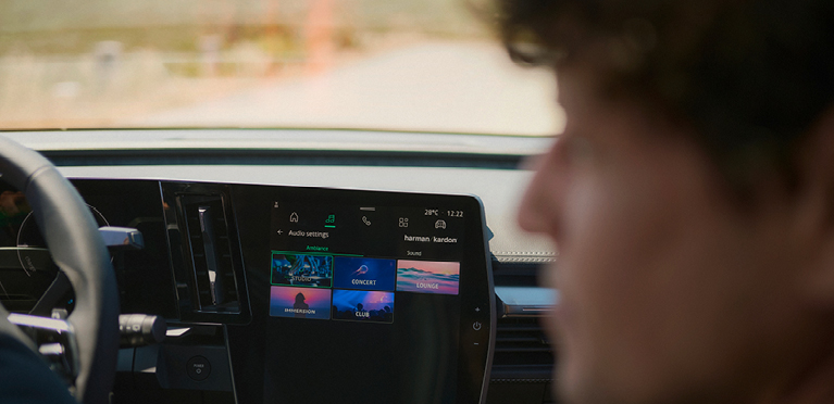 Das Infotainment des neuen Mitsubishi Eclipse Cross. Ein Mann schaut vom Beifahrersitz nach links, im Hintergrund ist das Infotainment des neuen Mitsubishi Eclipse Cross zu sehen.