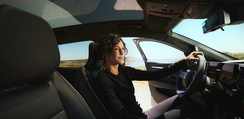 Der Fahrerbereich im neuen Mitsubishi Eclipse Cross Eine Frau sitzt mit offener Tür auf dem Fahrersitz des neuen Mitsubishi Eclipse Cross.