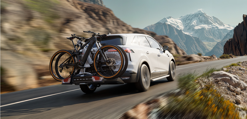 Grandis Zubehör Grandis mit Fahrradheckträger fährt einen Bergpass hinauf.