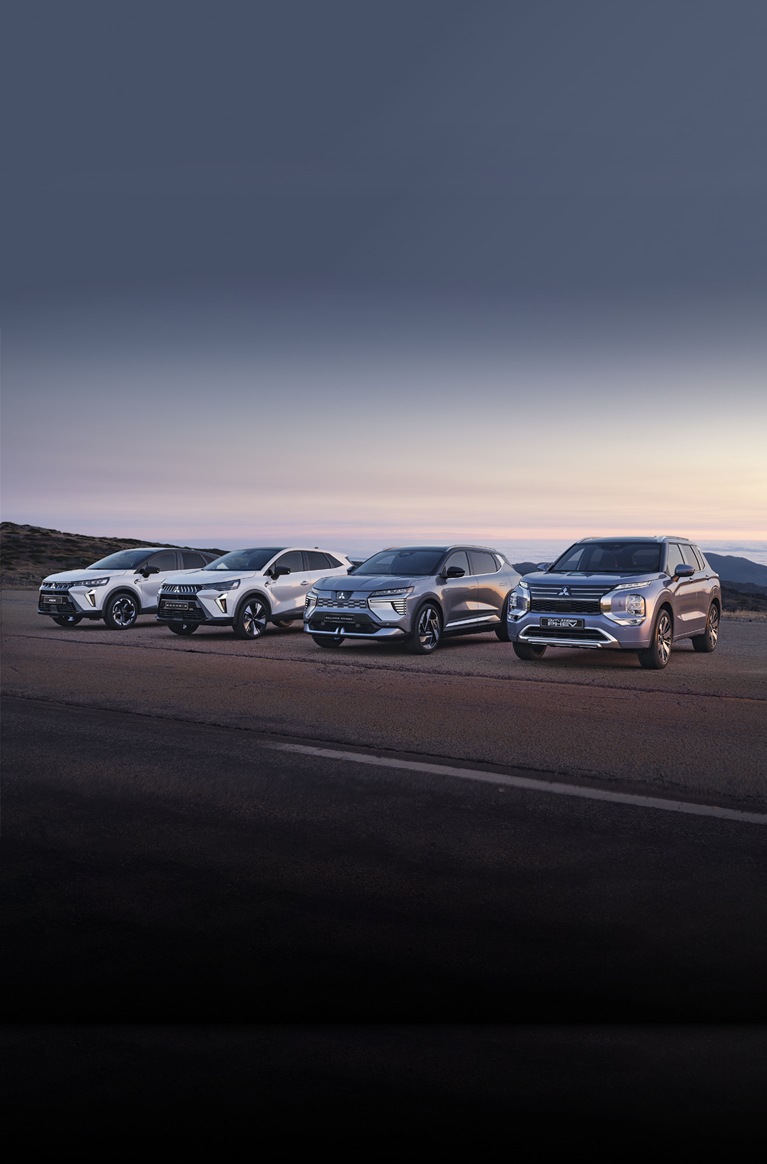Geschäftskunden: Header Vier Mitsubishi Modelle, darunter der Grandis, ASX, Eclipse Cross und Outlander, stehen nebeneinander auf einem offenen Platz vor weiter Landschaft bei Sonnenuntergang.