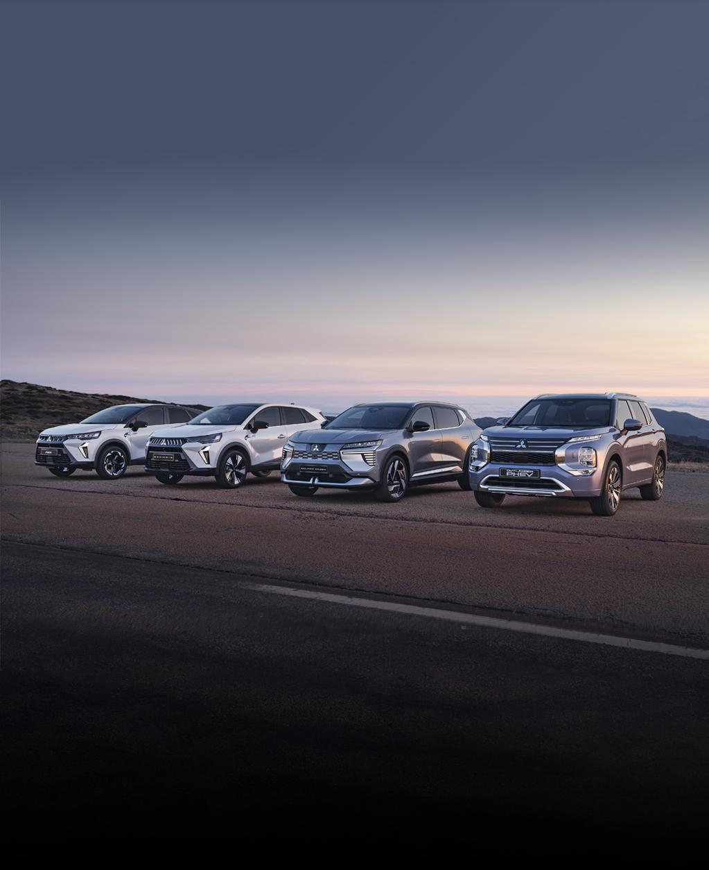 Geschäftskunden: Header Vier Mitsubishi Modelle, darunter der Grandis, ASX, Eclipse Cross und Outlander, stehen nebeneinander auf einem offenen Platz vor weiter Landschaft bei Sonnenuntergang.