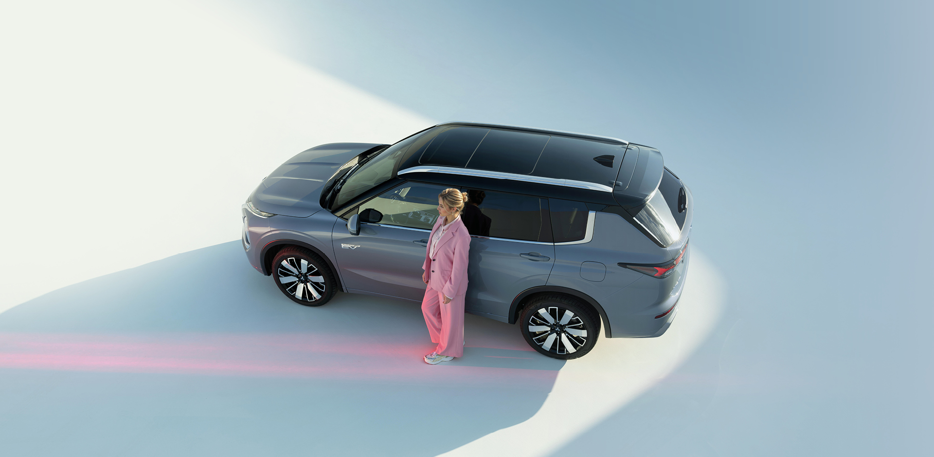 Der Outlander Frau lehnt an der Fahrertür des Outlanders