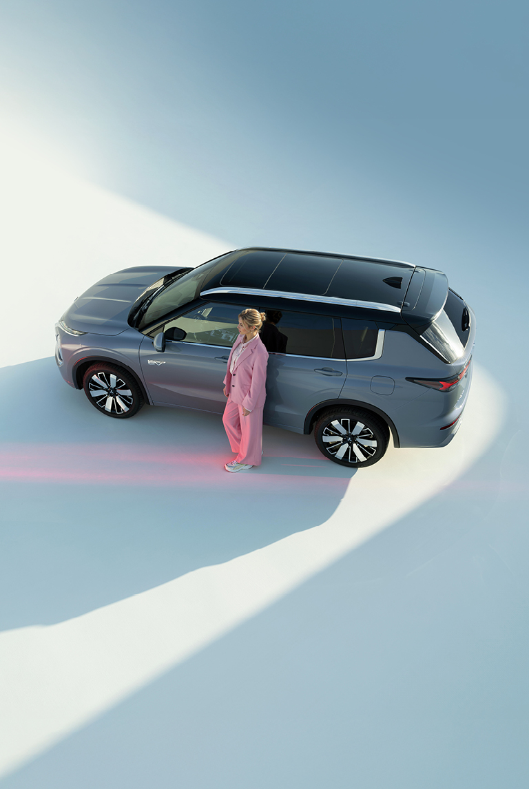 Der Outlander Frau lehnt an der Fahrertür des Outlanders