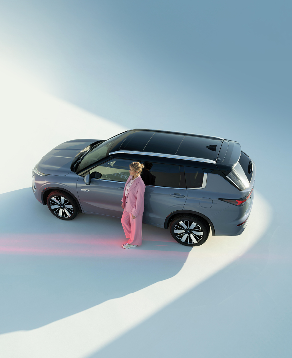 Der Outlander Frau lehnt an der Fahrertür des Outlanders