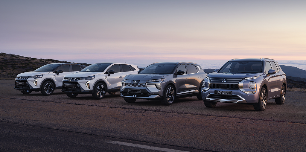Die Mitsubishi Modell-Range Die Mitsubishi ASX, Grandis, Eclipse Cross und Outlander stehen in der Dämmerung am Straßenrand.